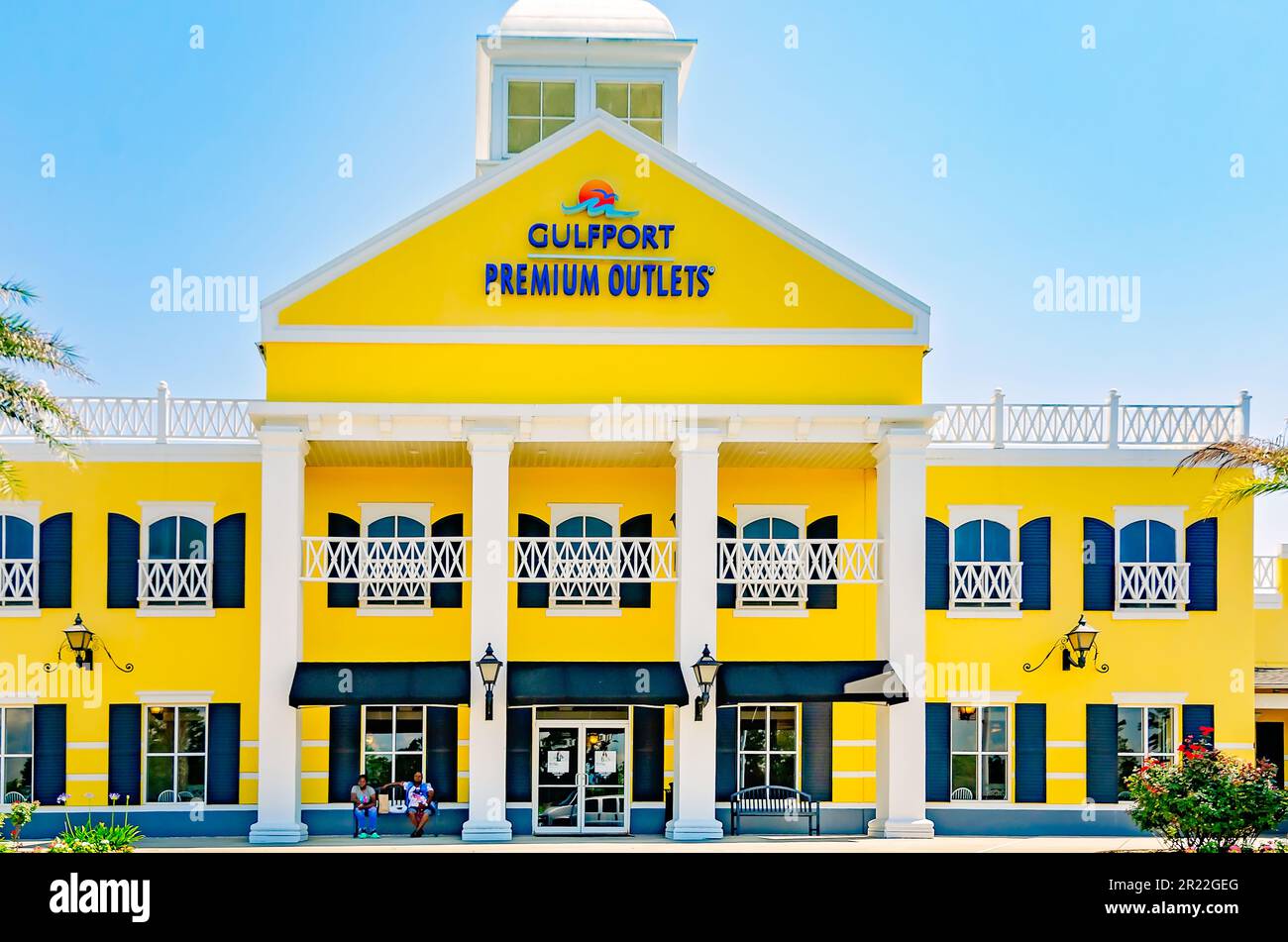 Customers sit outside Gulfport Premium Outlets, May 13, 2023, in