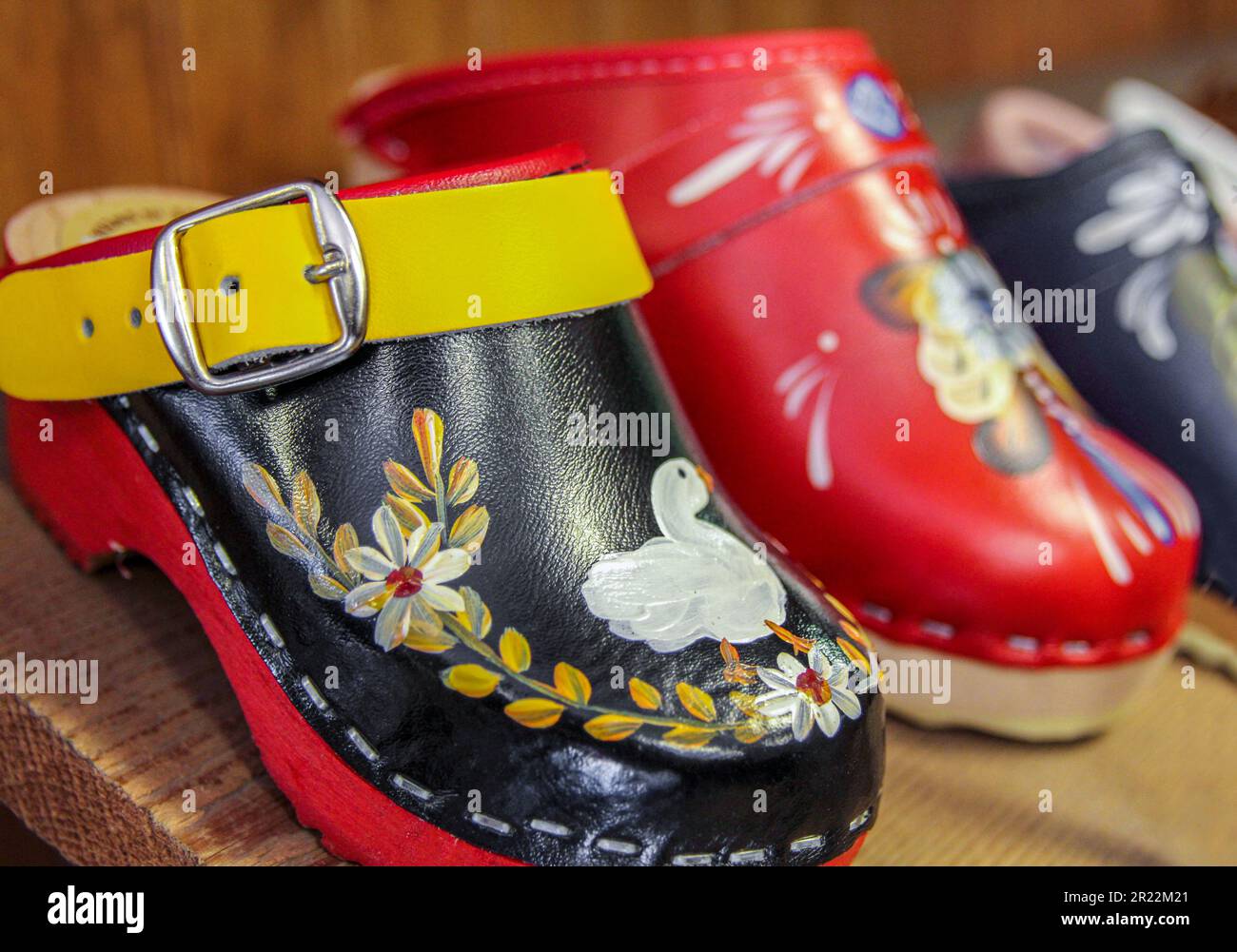 Pair of hand-painted, handmade Swedish clogs on a wooden shelf in a shoe store in Solvang, California. Stock Photo