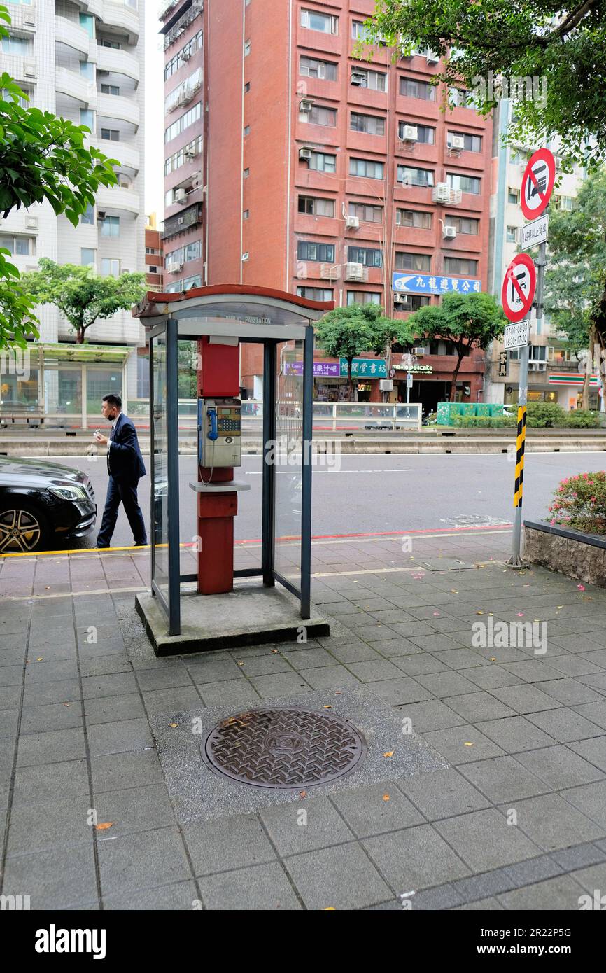 Chunghwa Telecom public pay phone booth in Taipei, Taiwan; coin operated, with option to pay with iPass, iCash, EasyCard, or Taiwan Easy Go; street. Stock Photo