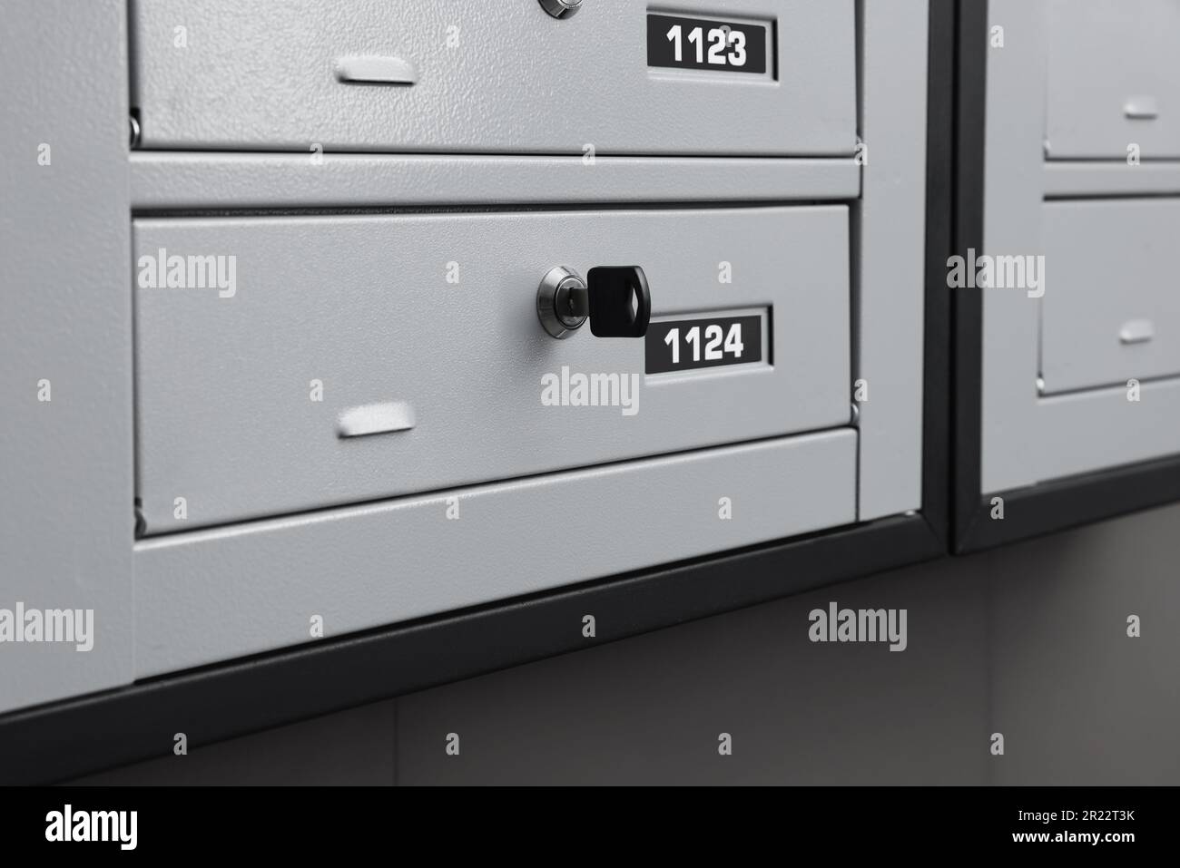 Closed metal mailboxes with keyholes and sequence numbers indoors Stock
