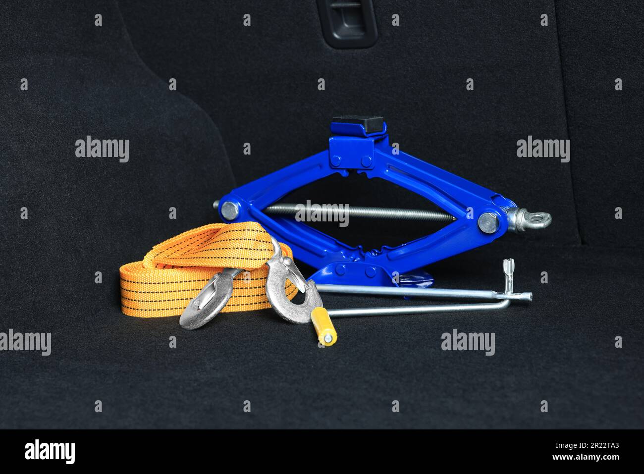 Scissor jack and towing strap in trunk. Car safety equipment Stock