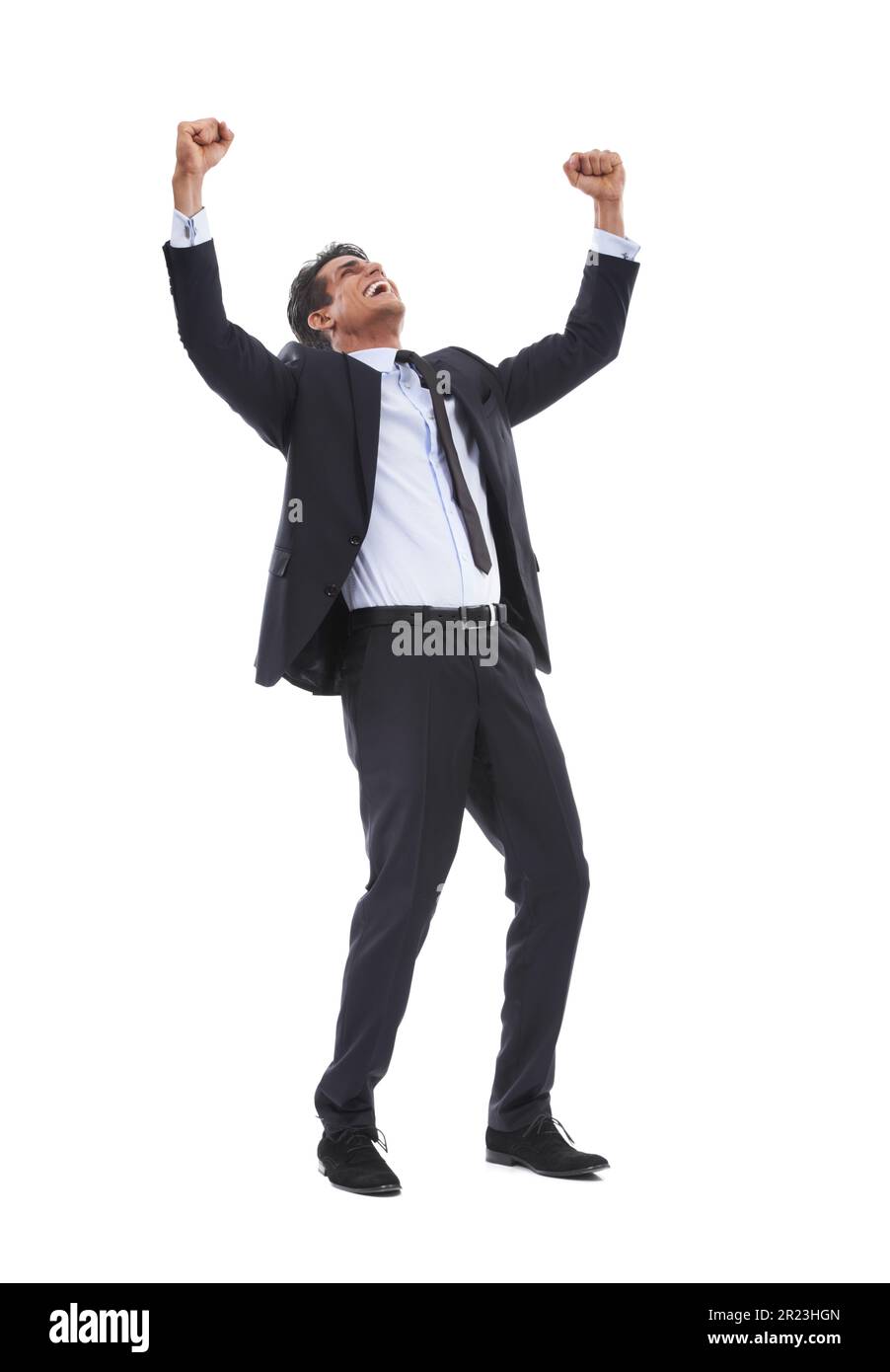 Basking in his success. A happy young businessman standing with fists raised int he air in gesture of victory against a white background. Stock Photo