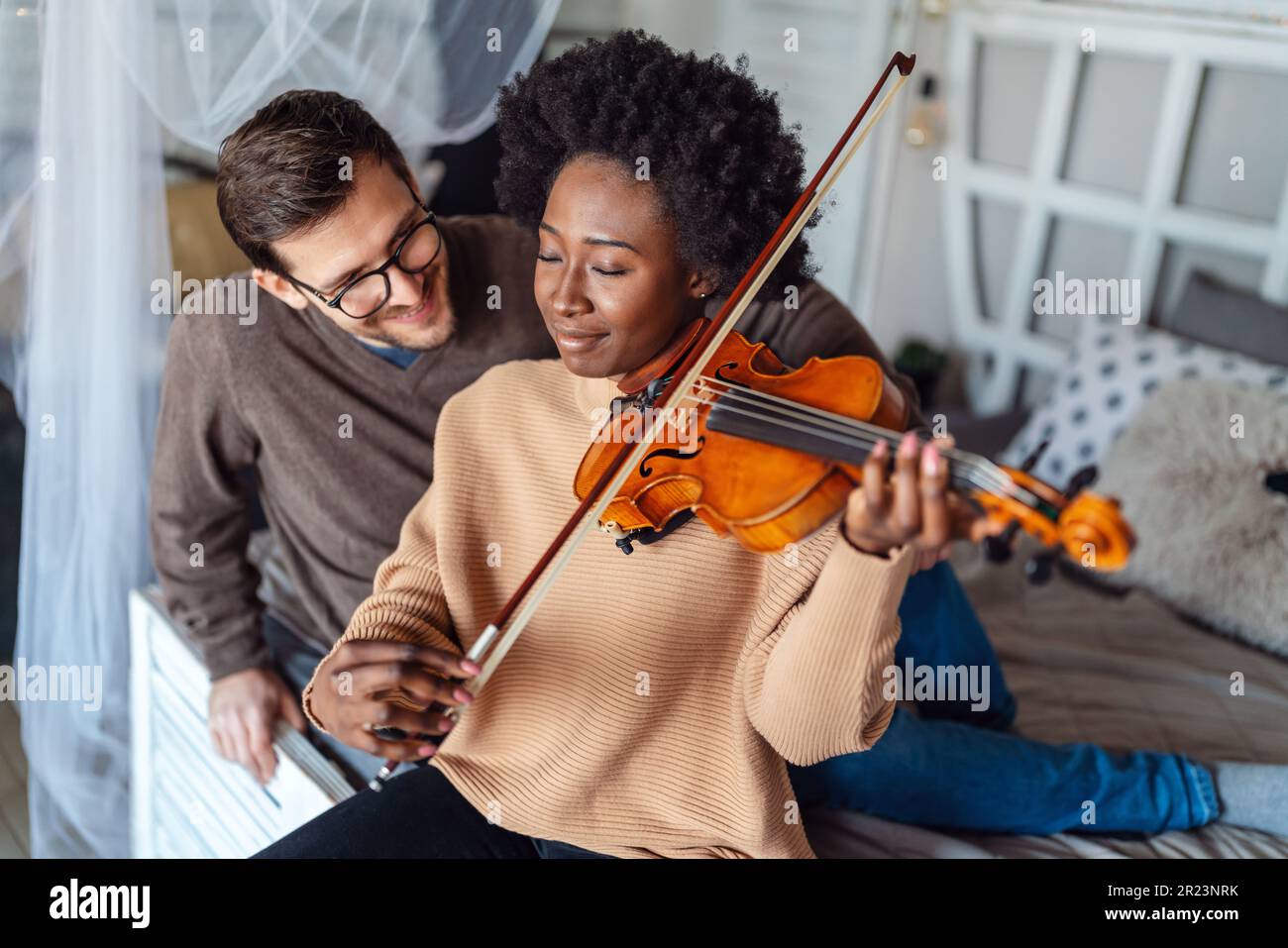 Private male music teacher giving violin lessons to a woman home. Couple love romance concept Stock - Alamy