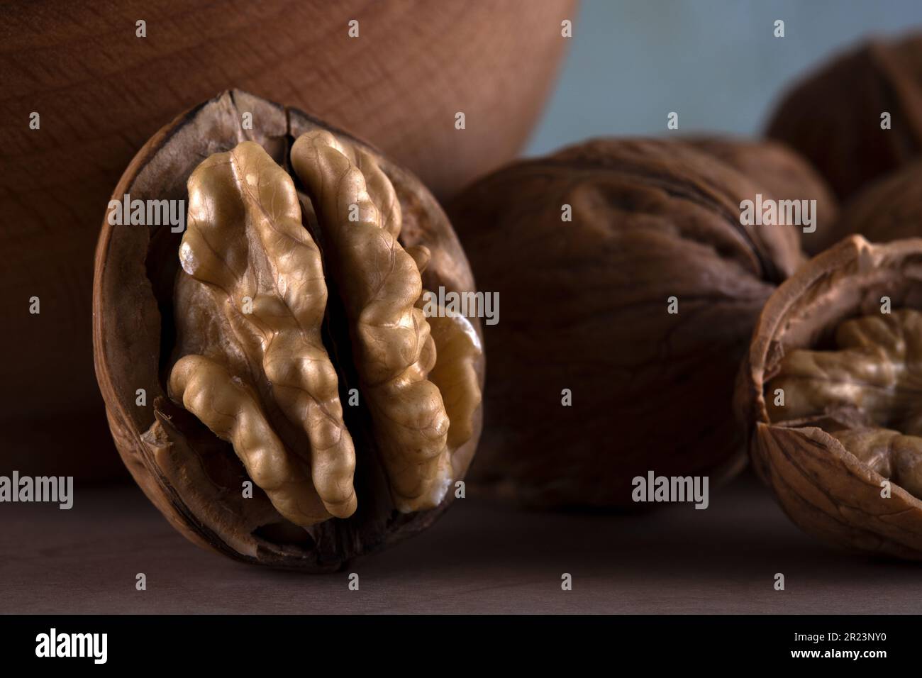 Walnut kernels and cracked walnuts on wooden table Stock Photo
