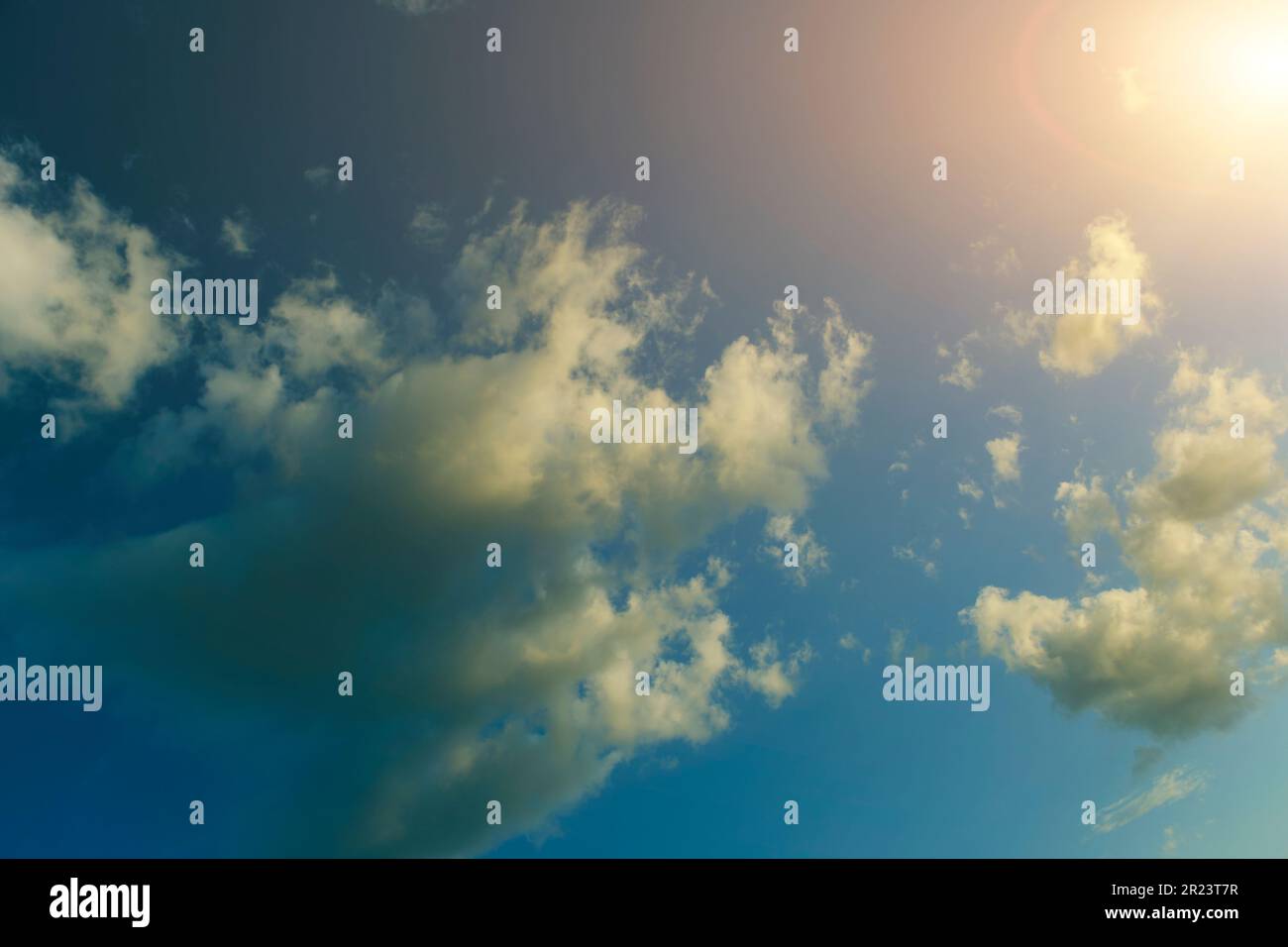 Clouds against blue sky against bright sun Stock Photo