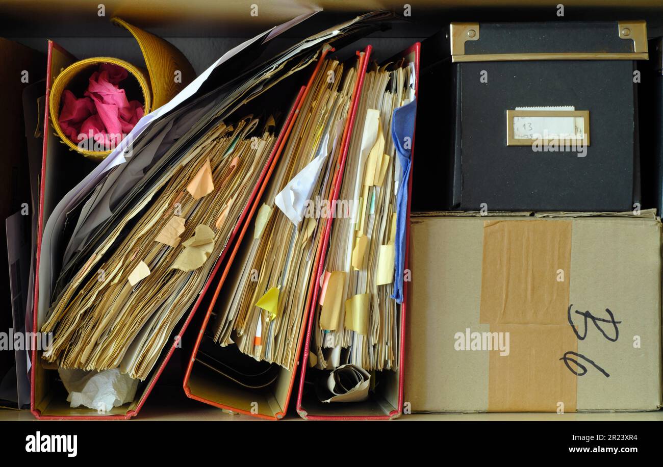 messy file folders,red tape, bureaucracy,aministration,business concept. Vintage analog film colors. Stock Photo