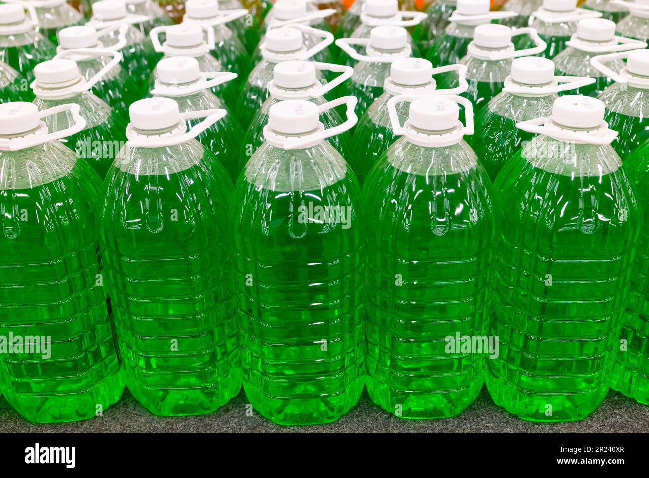 Green technical fluid in plastic bottles at the supermarket. Stock Photo