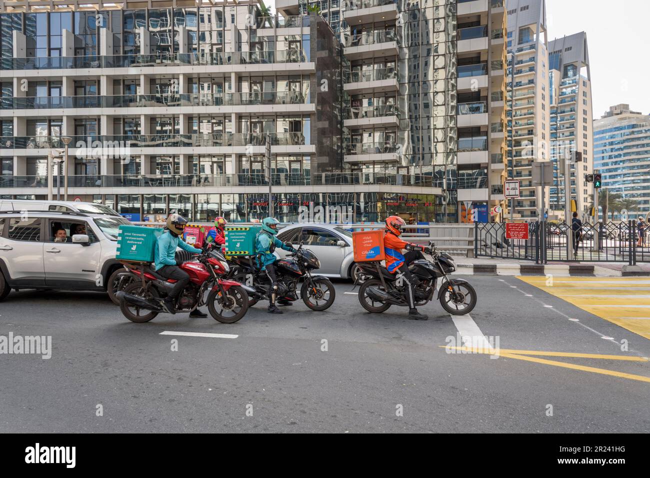 Food delivery motorbikes wait at traffic lights near Dubai's Marina
