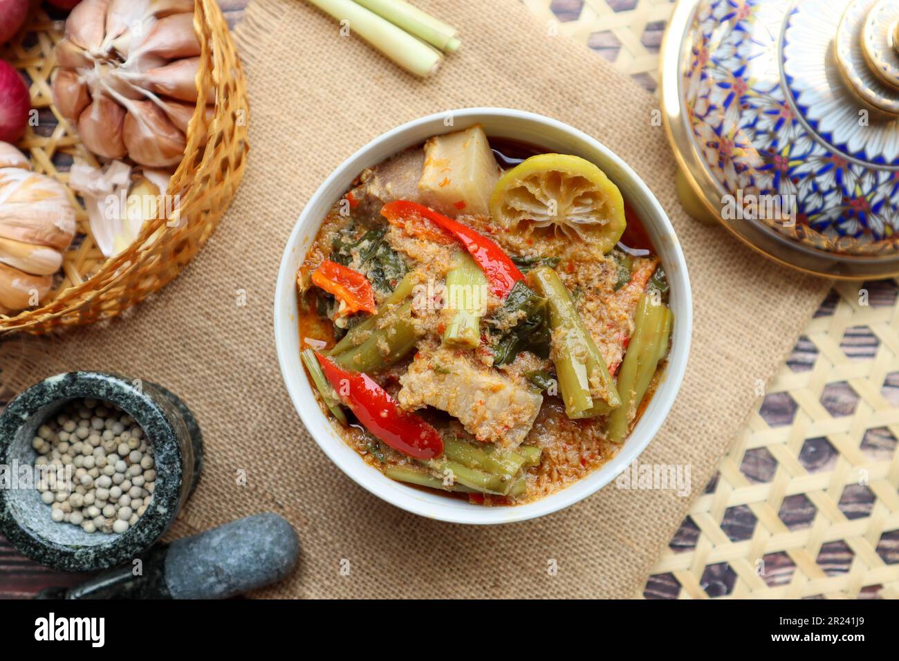 Thai red curry with morning glory and pork belly - Authentic Thai food called Kang Tay po served in Benjarong porcelain Stock Photo