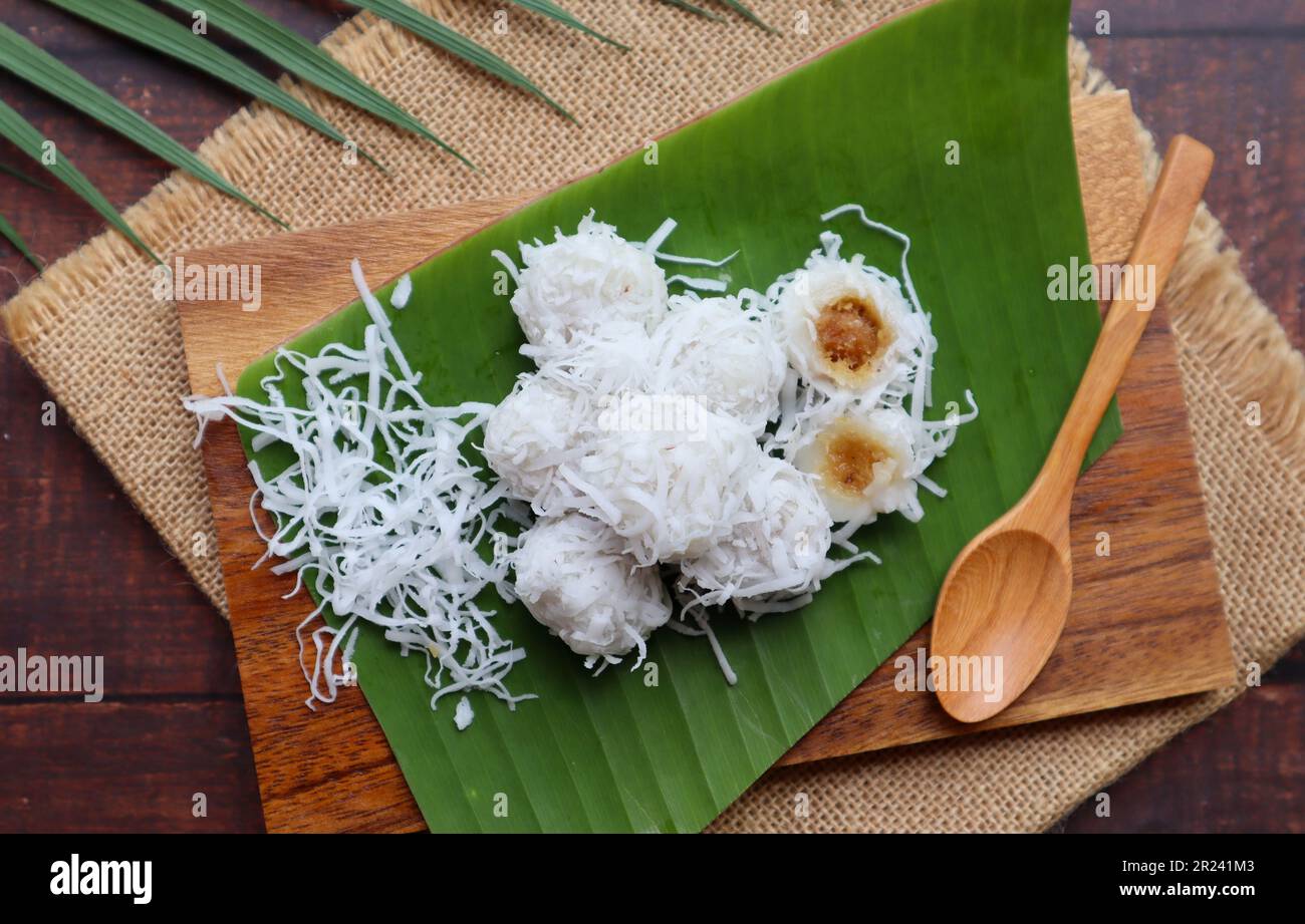 Kanom Tom - Thai dessert of boiled rice flour dumpling coated with shedded coconut and filled with coconut melted in palm sugar at top view Stock Photo