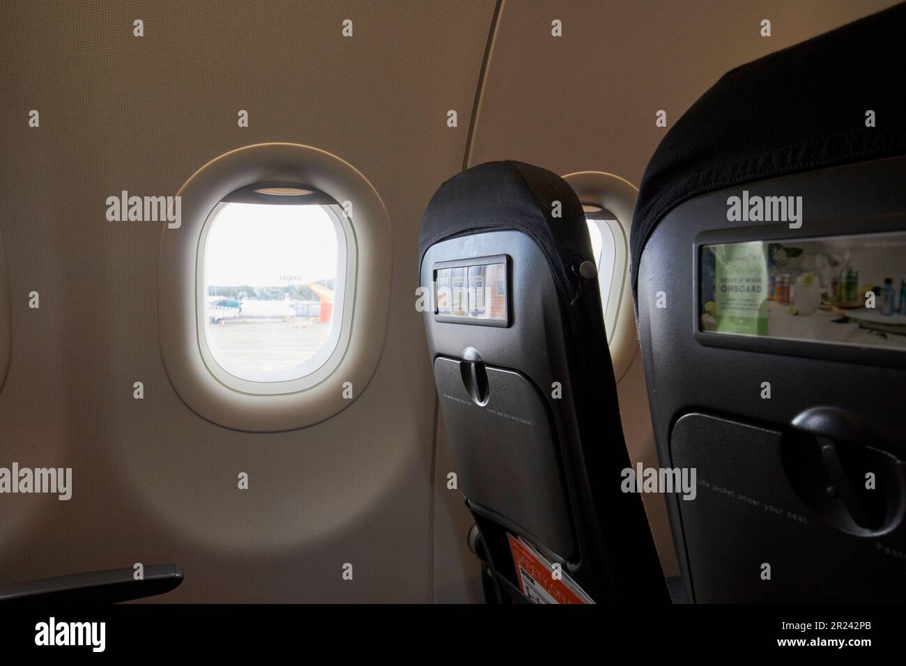 row of seats in easyjet aircraft looking out at george best belfast city airport belfast northern ireland uk Stock Photo