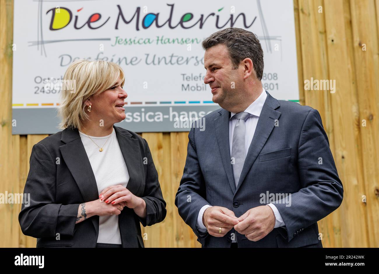 Osterby, Germany. 17th May, 2023. Hubertus Heil (SPD), Federal Minister of Labor, talks to the owner, master painter Jessica Hansen, during a visit to the business 'Die Malerin'. The minister thus fulfills his promise from the broadcast 'Hart aber fair' on March 13, 2023. Hansen has introduced the four-day week in her business and has had positive experience in recruiting skilled workers. Credit: Axel Heimken/dpa/Alamy Live News Stock Photo