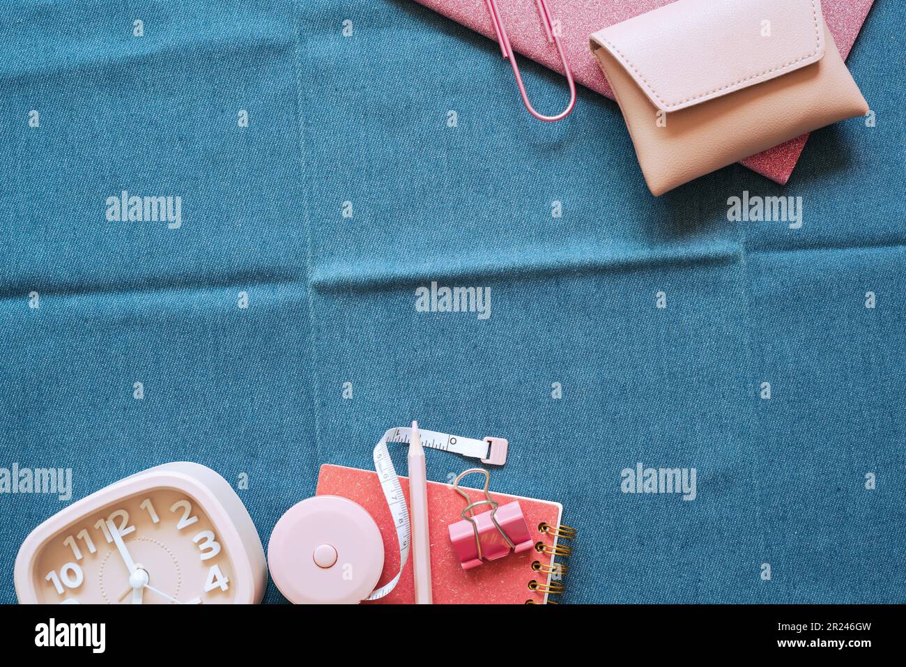 Pink stationery office supply on blue fabric desk background. flat lay, top view, copy space Stock Photo