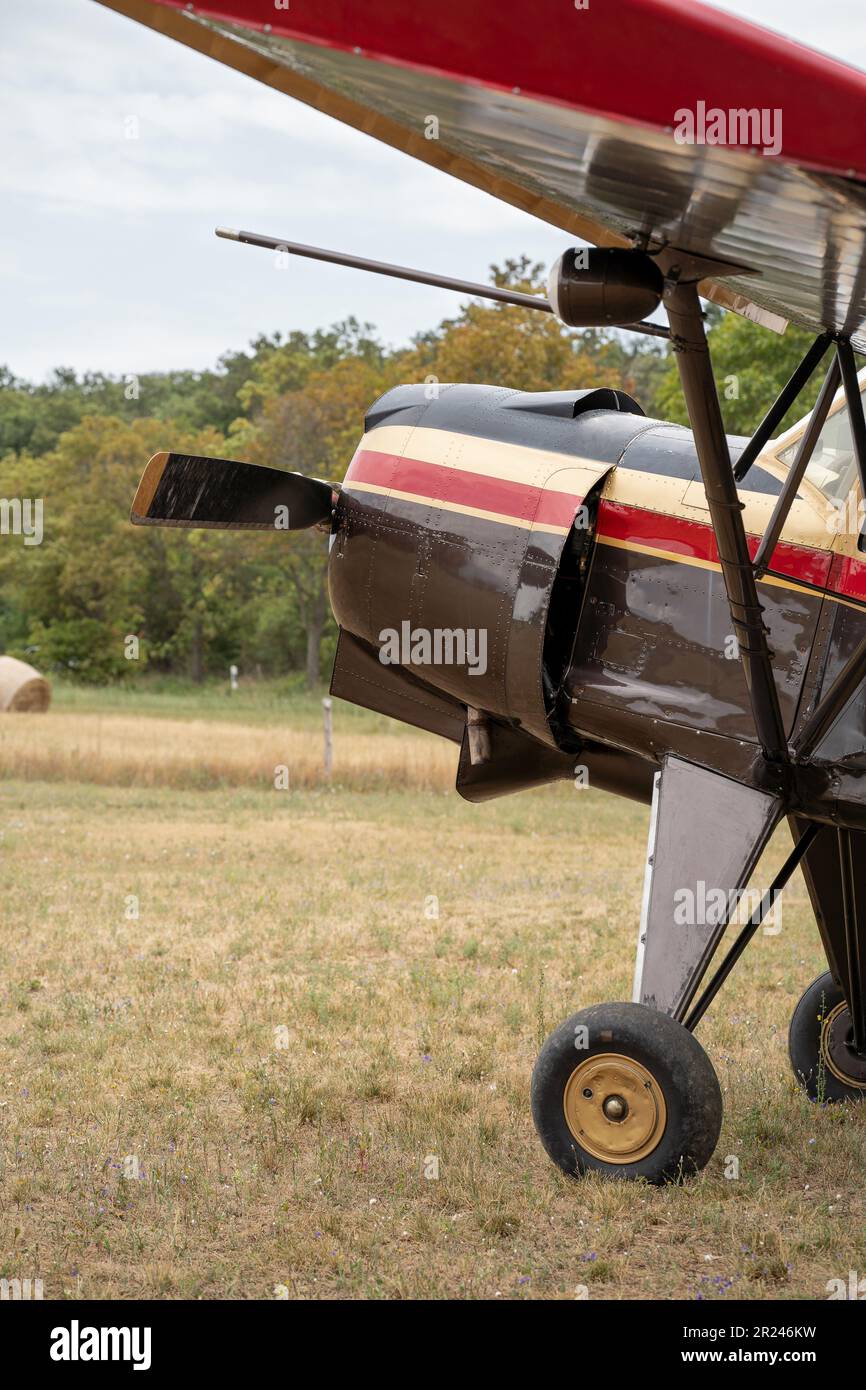 Detail of a classic airplane on the field. Biplane. Nine cylinder radial engine. Landscape in the background. Stock Photo