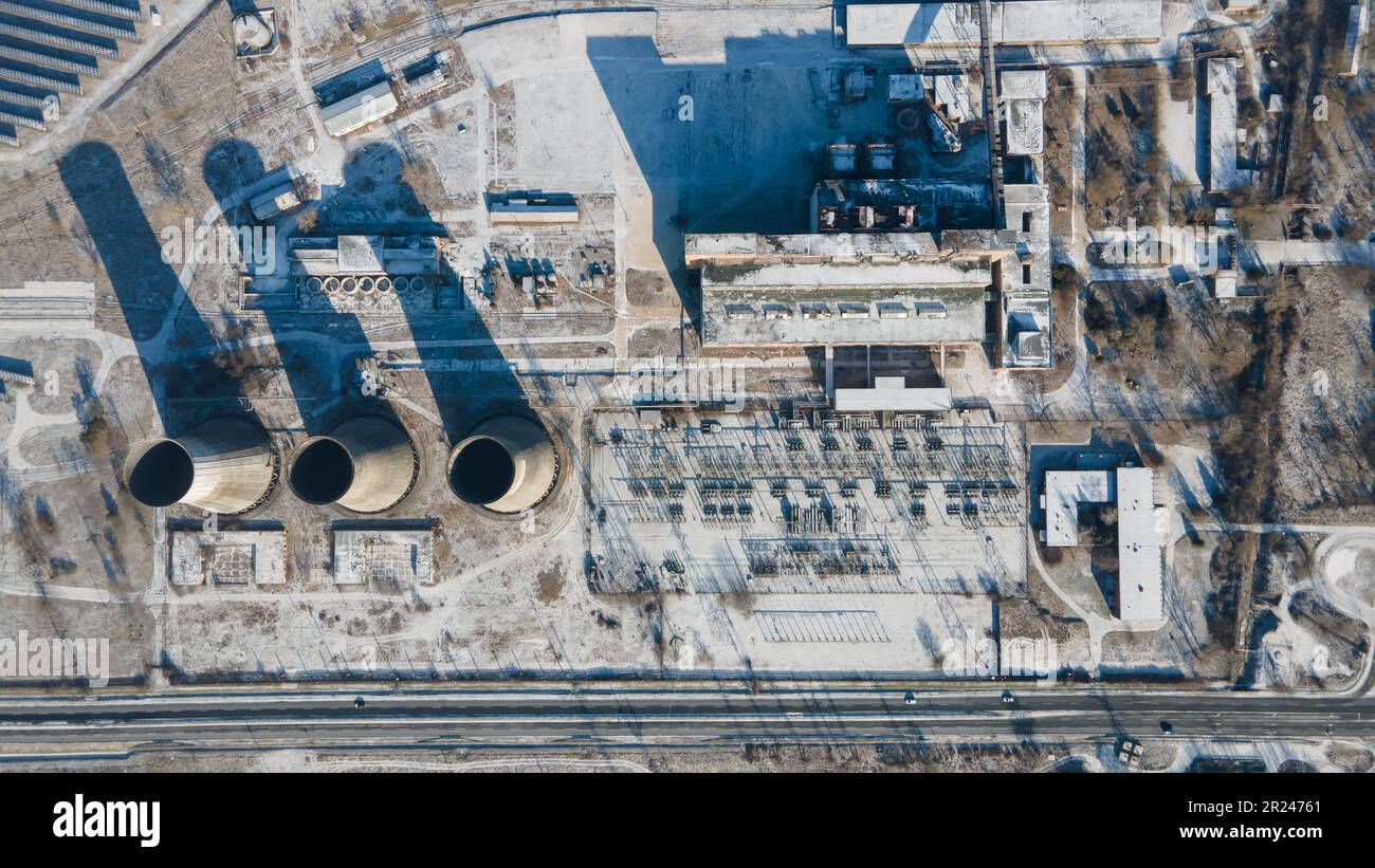 Aerial view of an abandoned thermal power plant in Hungary. Winter landscape. Non working and closed. Cooling towers. Ruined buildings. Stock Photo