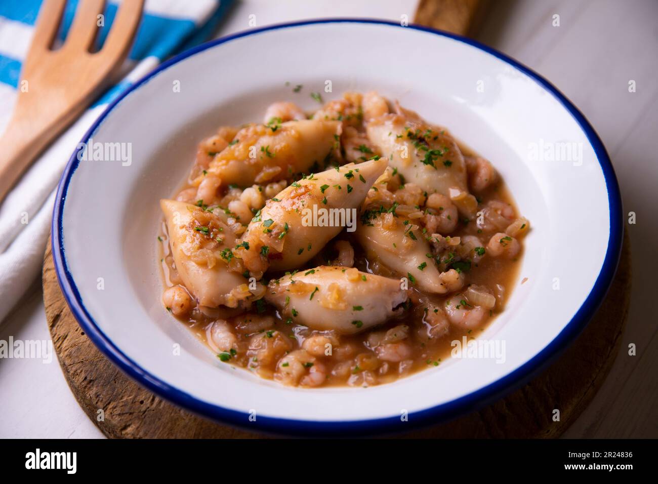 Baby Squid stew with potatoes and prawns. Traditional Spanish recipe
