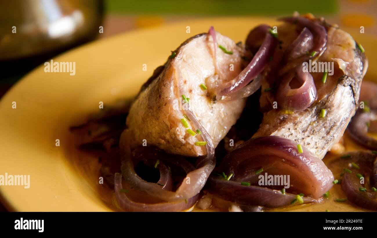 Hake fish cooked with red onion in a spanish restaurant Stock Photo Alamy