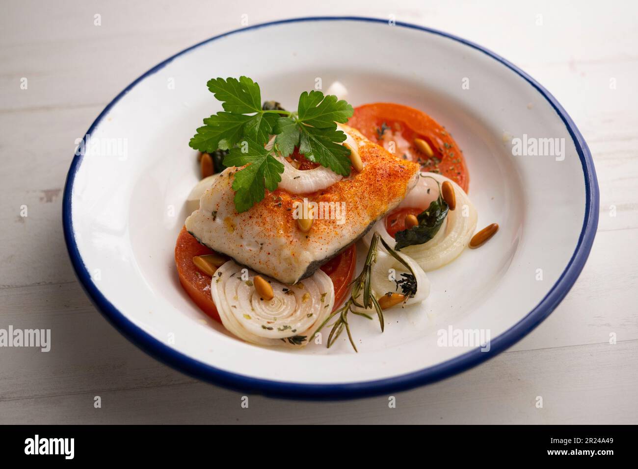 Baked hake fillet cooked with tomato and onion. Traditional Spanish