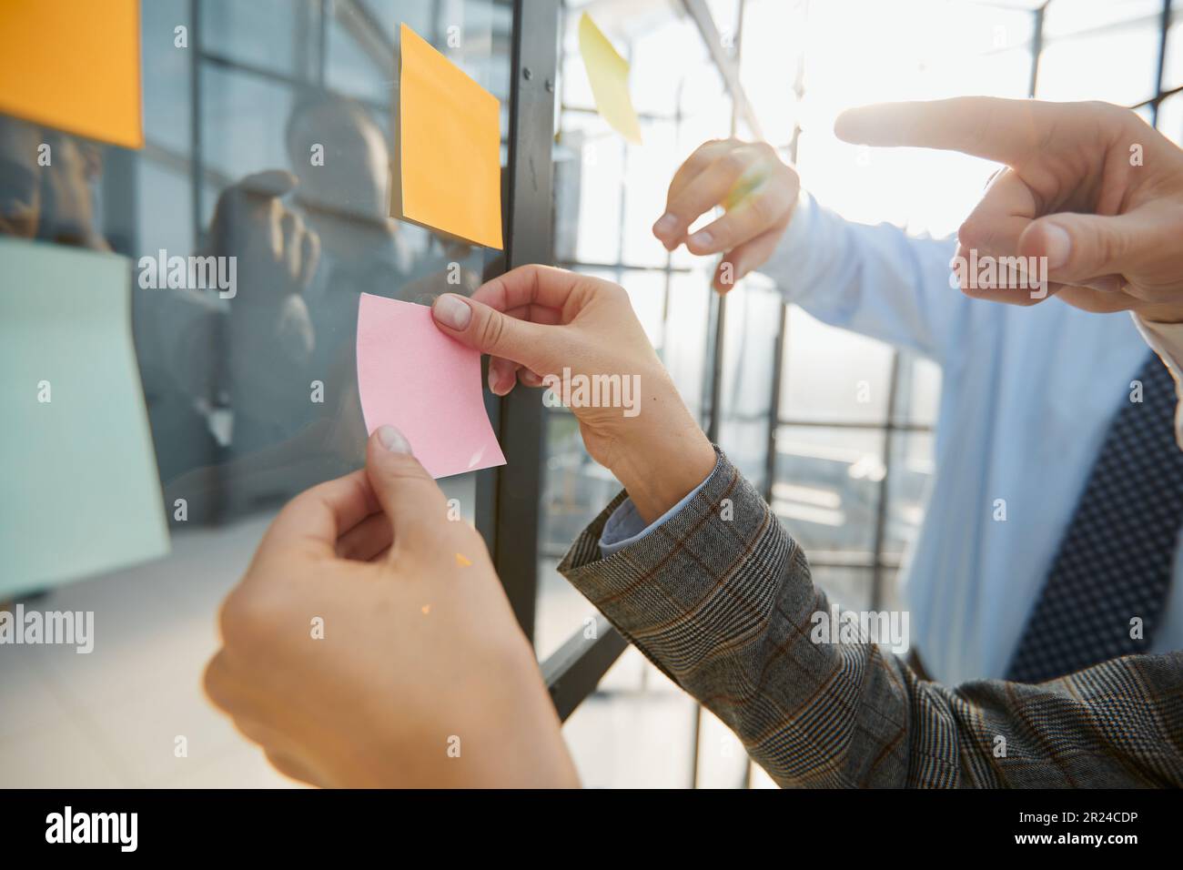 hand glues empty sticker on office window. Stock Photo