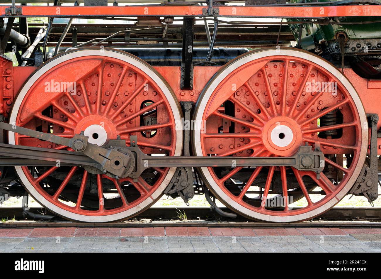 Big red wheels, flywheels, connecting rods and other machinery of an old steam locomotive. Stock Photo