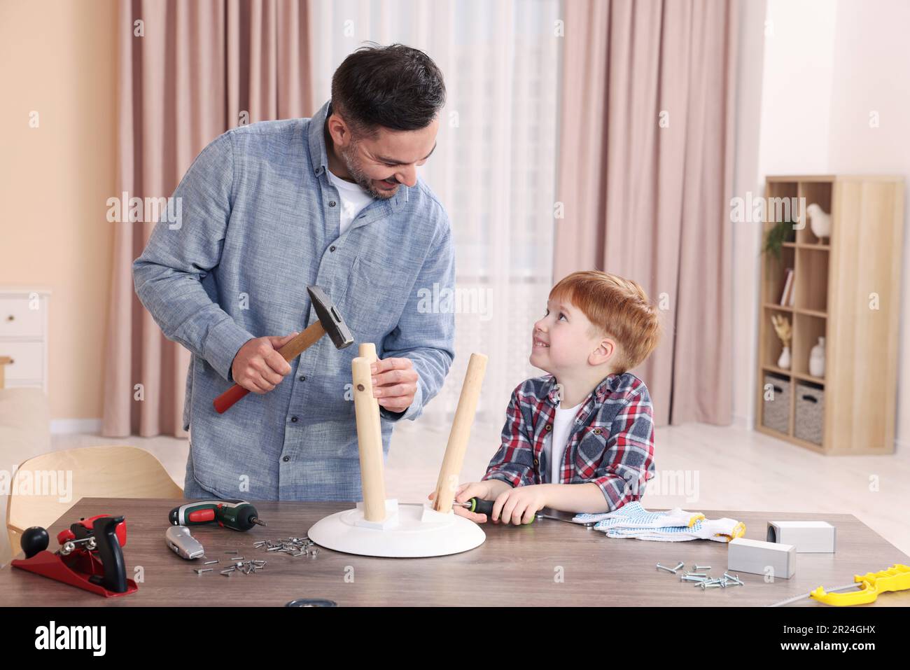 Father teaching son how to make stool at home. Repair work Stock Photo Alamy