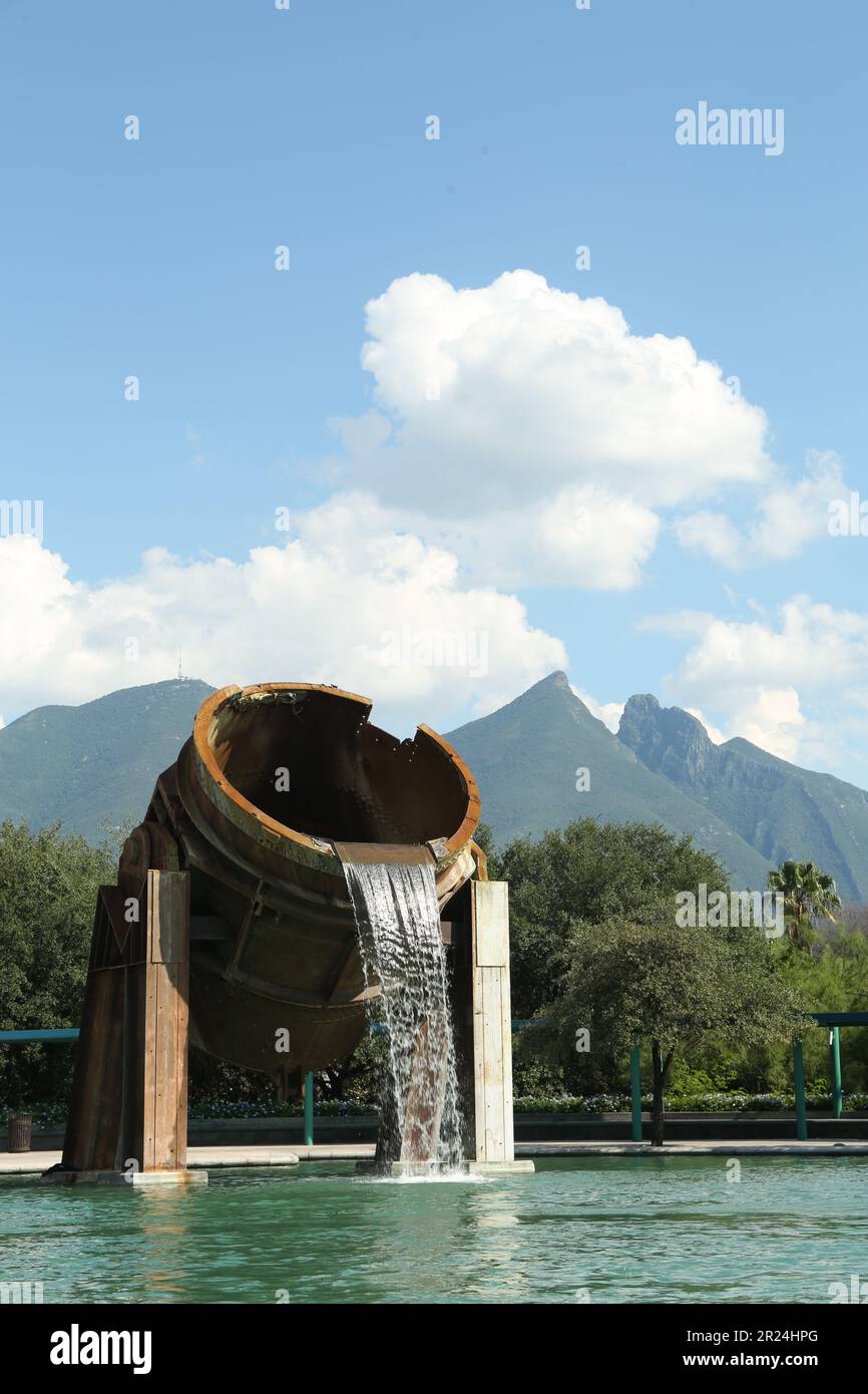 Monterrey, Mexico - September 11, 2022: Fuente de Crisol (Melting Pot Fountain) and beautiful mountains in Parque Fundidora Stock Photo