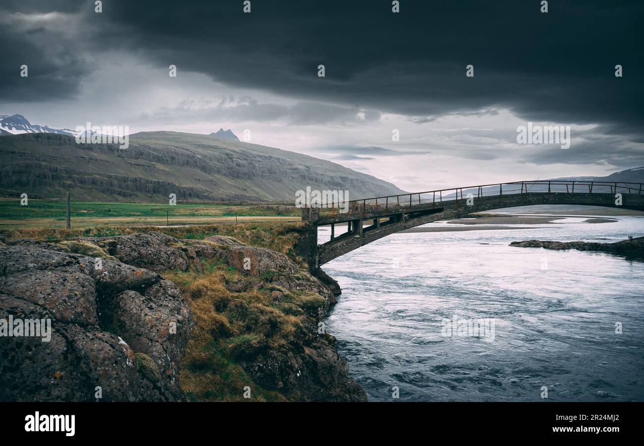 A spectacular vertical view of a bridge arching over a body of water in the East Fjords, Iceland Stock Photo