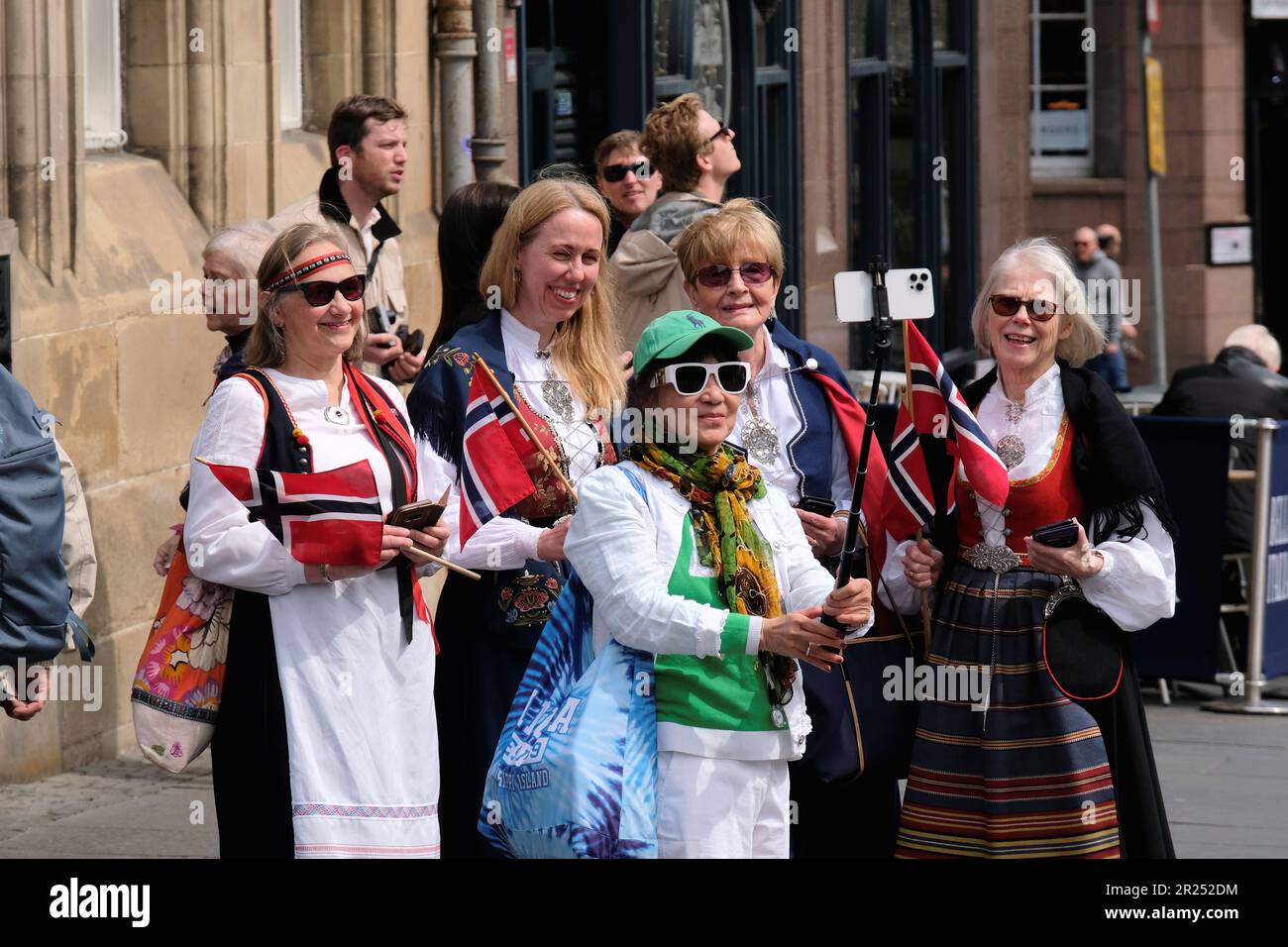 Edinburgh, Scotland, UK. 17th May 2023. Organised by the Royal Norwegian Consulate General, this year’s celebration of Norwegian Constitution day, with a parade and march from Cockburn Street along the High Street, finishing at the memorial stone in Princes Street Gardens with a ceremony. On the Royal Mile, taking a selfie and wearing traditional dress. Credit: Craig Brown/Alamy Live News Stock Photo