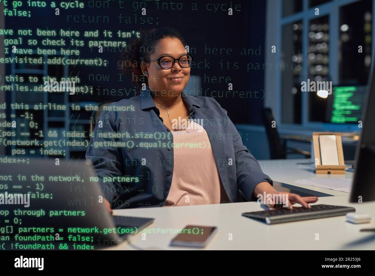 African American woman typing codes on computer while sitting at her ...