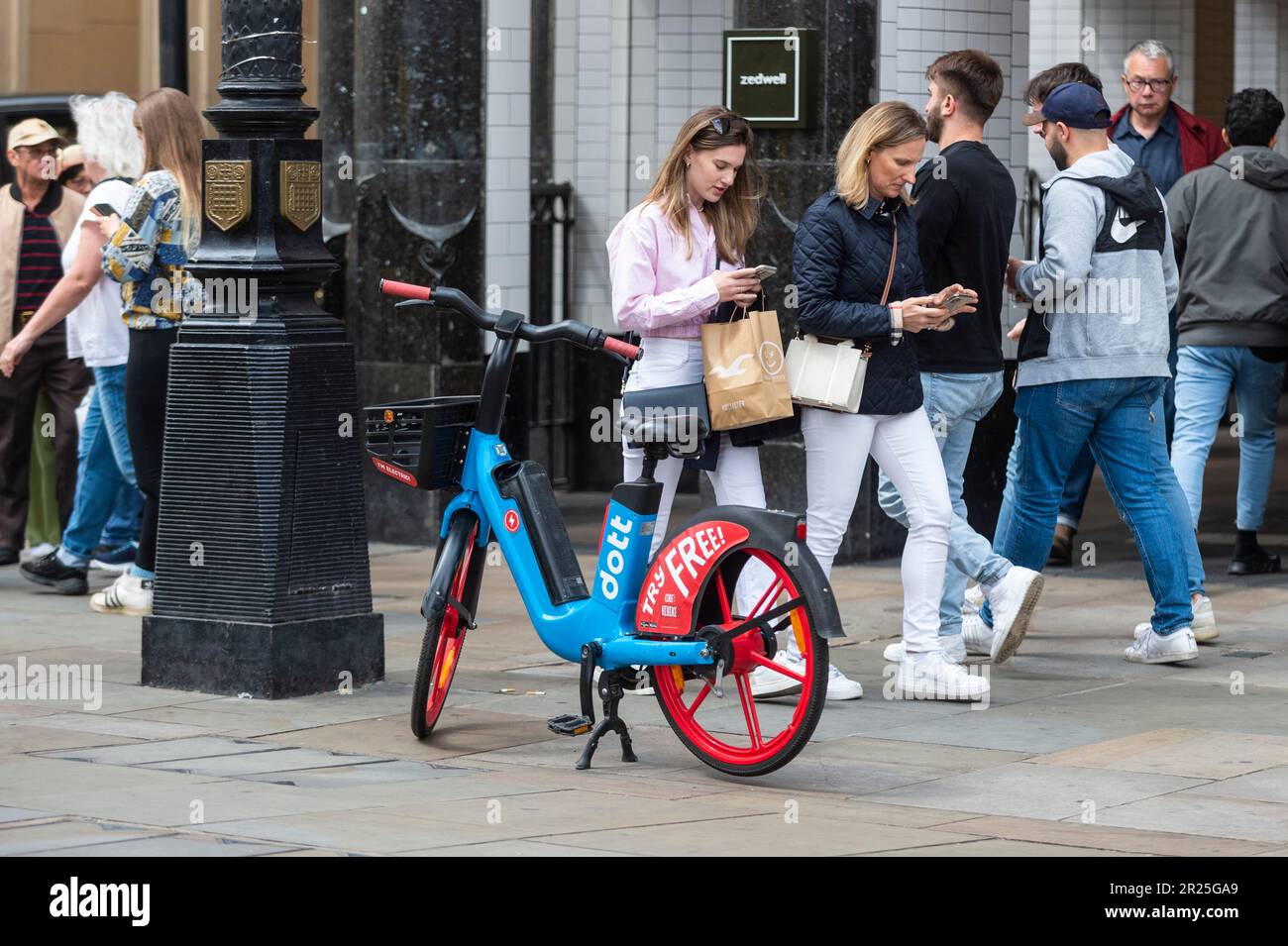 London, UK. 17 May 2023. The public passes an electric hire cycle on a