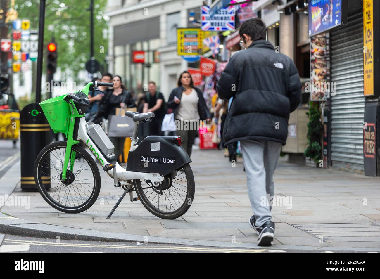 London, UK. 17 May 2023. The public passes an electric hire cycle on a