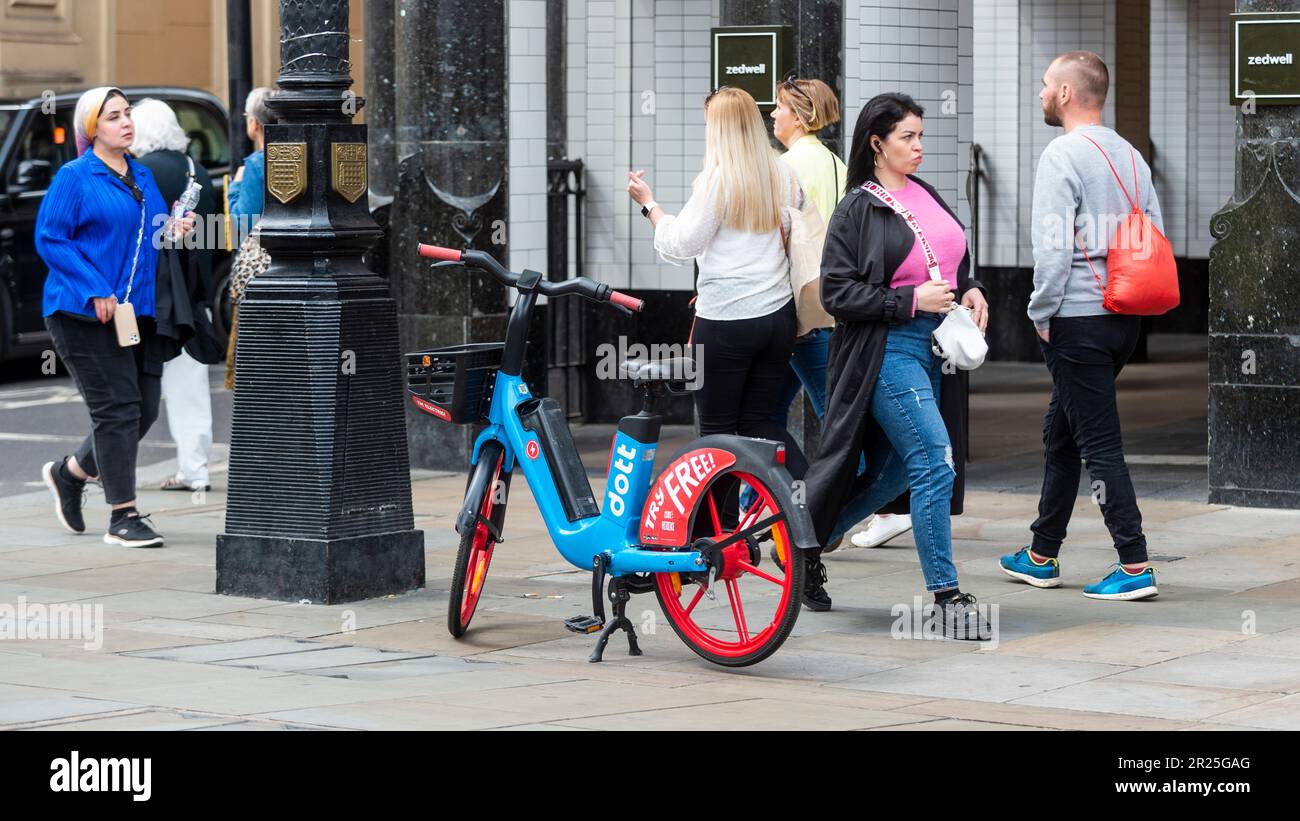 London, UK. 17 May 2023. The public passes an electric hire cycle on a