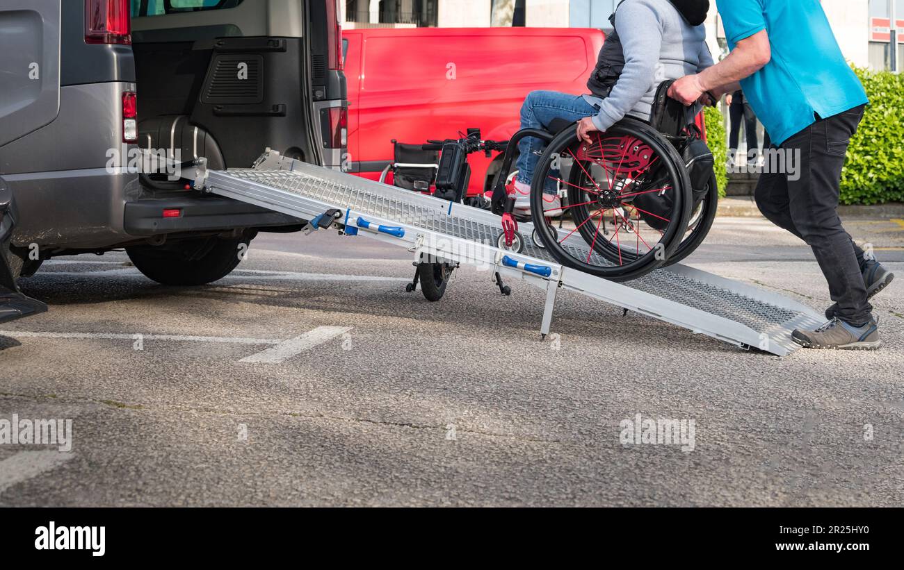 Person on wheelchair with disability using accessible car ramp for