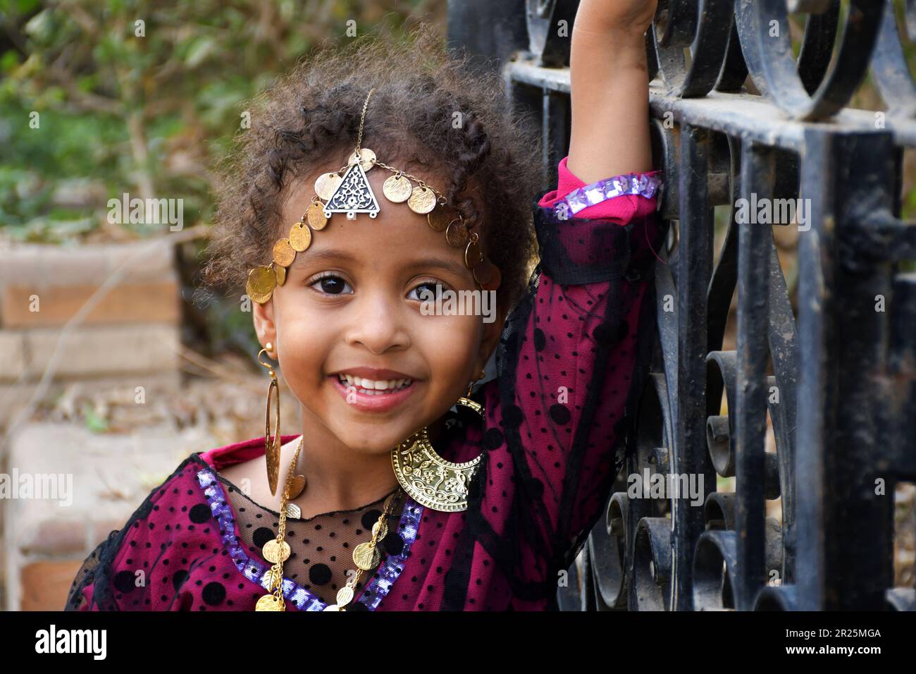 Portrait of a beautiful little girl with curly hair wearing traditional ...