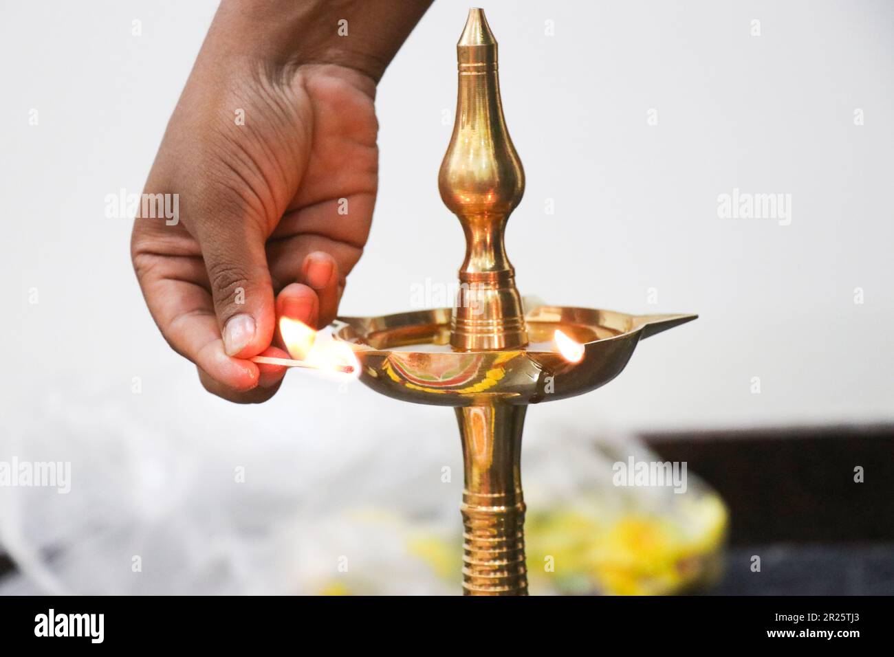 A traditional lamp or an oil lamp is being lit. Indian pooja is