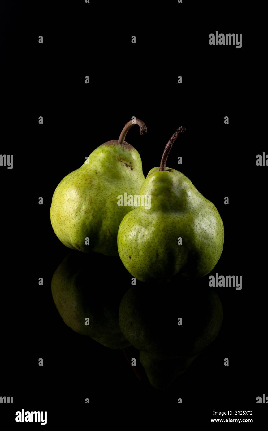 Two green ripe pears on a black background Stock Photo