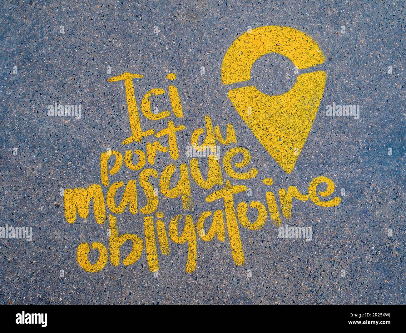 Spray painted stencil warning on pavement for wearing a mask during Covid pandemic - France. Stock Photo