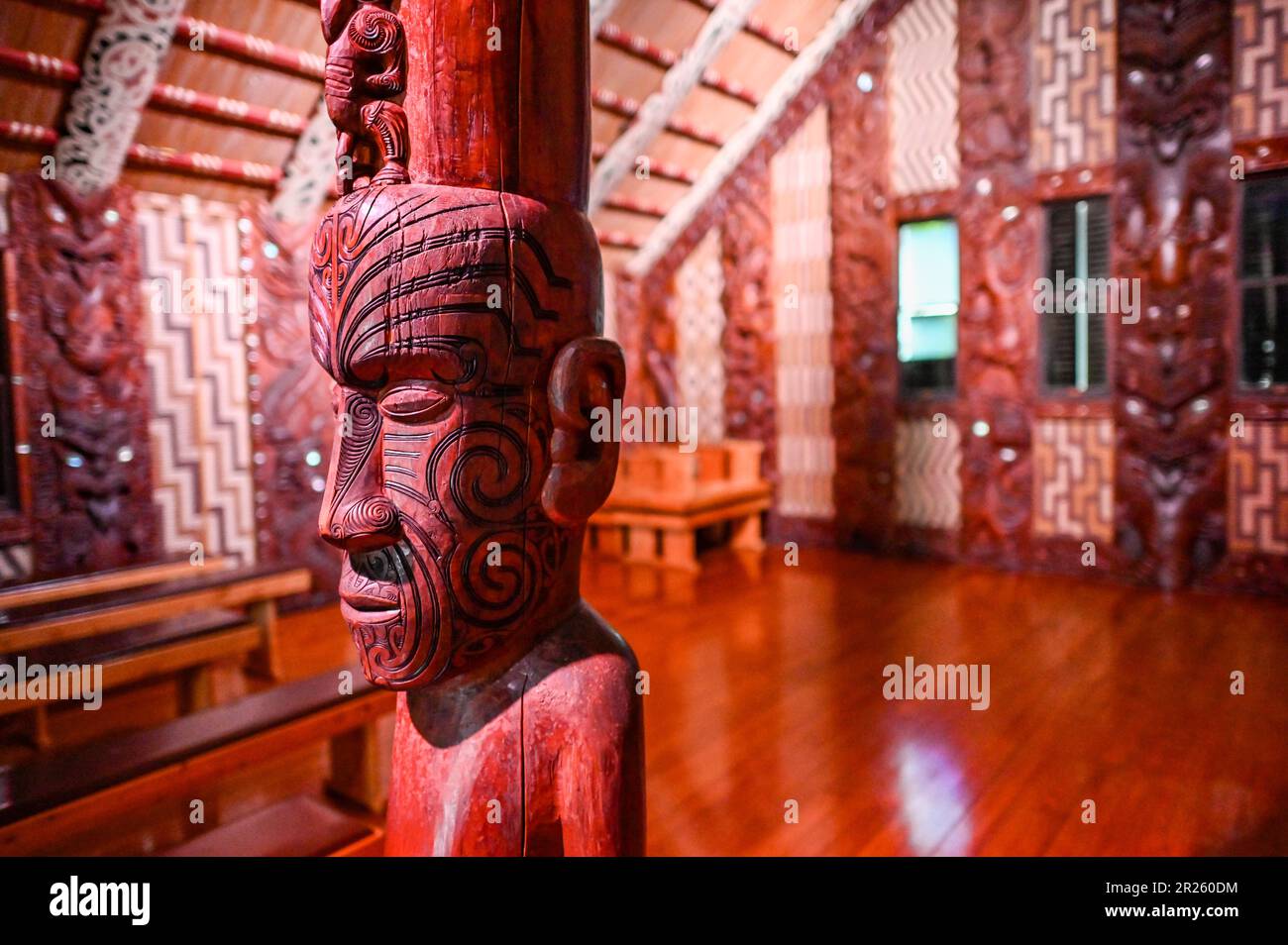 The ceremonial house at Waitangi is called the Whare Rūnanga. It is a significant structure located within the Waitangi Treaty Grounds in New Zealand. The Whare Rūnanga serves as a symbol of partnership and unity between Māori and the British Crown.  The Whare Rūnanga is a traditional Māori meeting house built in the style of a carved wharenui (large house). It was constructed in 1940 to commemorate the centenary of the signing of the Treaty of Waitangi Stock Photo