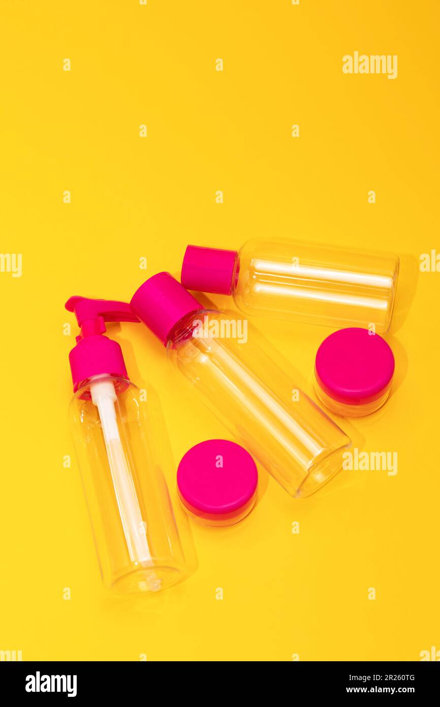 Top view travel bottle kit for liquids, cream. Toiletries Beauty Kit on yellow orange background