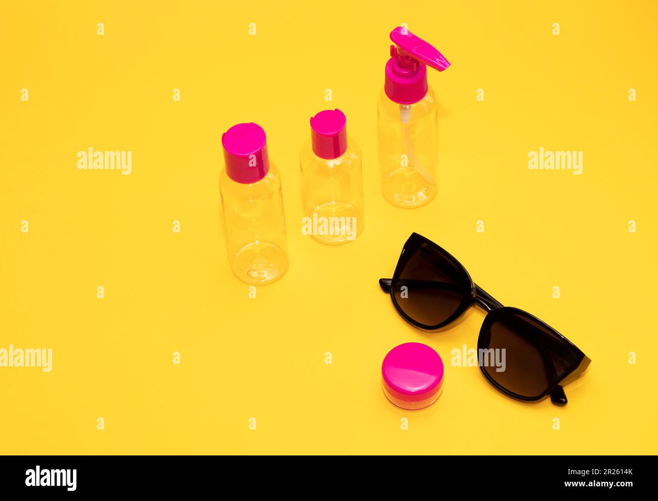 Airplane luggage fuchsia bottle container size with sun glasses on