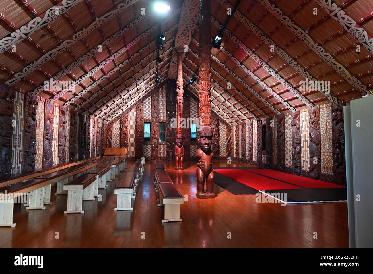 The ceremonial house at Waitangi is called the Whare Rūnanga. It is a significant structure located within the Waitangi Treaty Grounds in New Zealand. The Whare Rūnanga serves as a symbol of partnership and unity between Māori and the British Crown.  The Whare Rūnanga is a traditional Māori meeting house built in the style of a carved wharenui (large house). It was constructed in 1940 to commemorate the centenary of the signing of the Treaty of Waitangi Stock Photo
