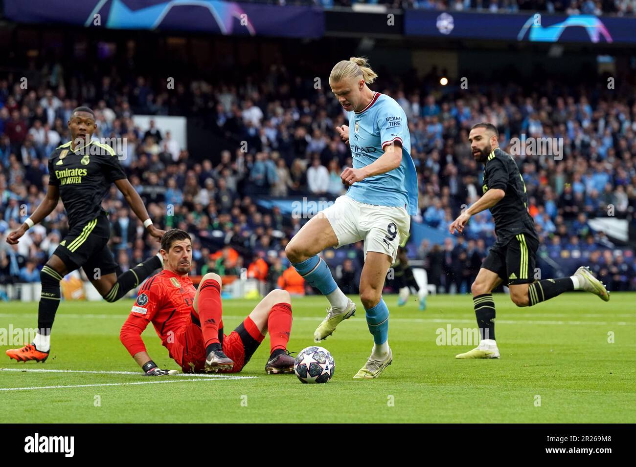 Manchester City's Erling Haaland rounds Real Madrid goalkeeper Thibaut ...