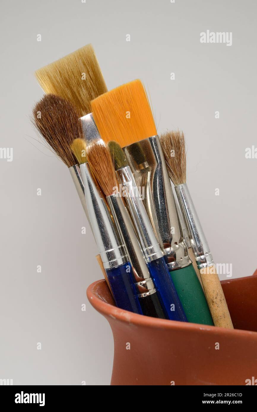 artistic brushes in a ceramic pot on a neutral background Stock Photo