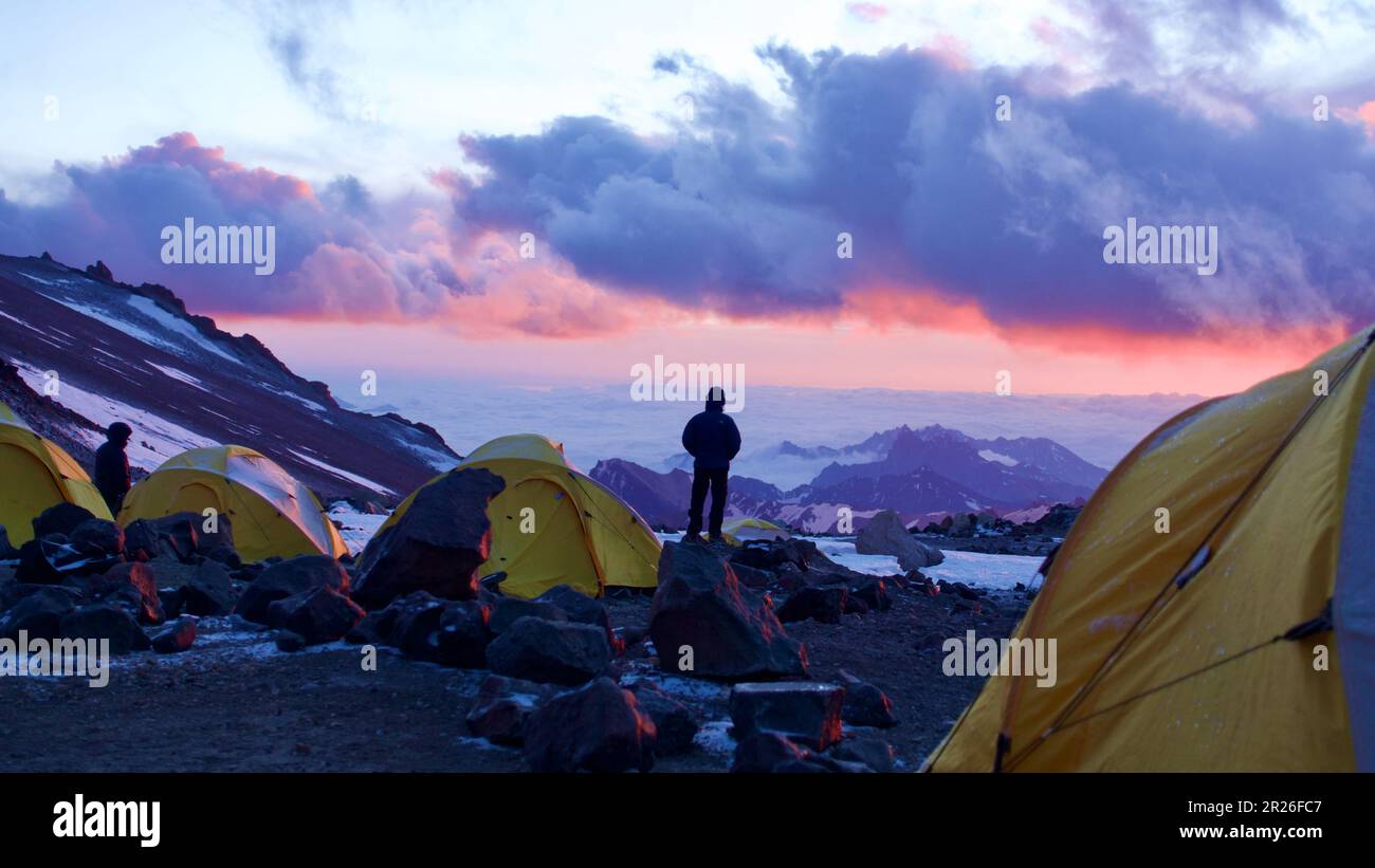 Climber enjoying break-taking sunset from high camp on Aconcagua Stock Photo