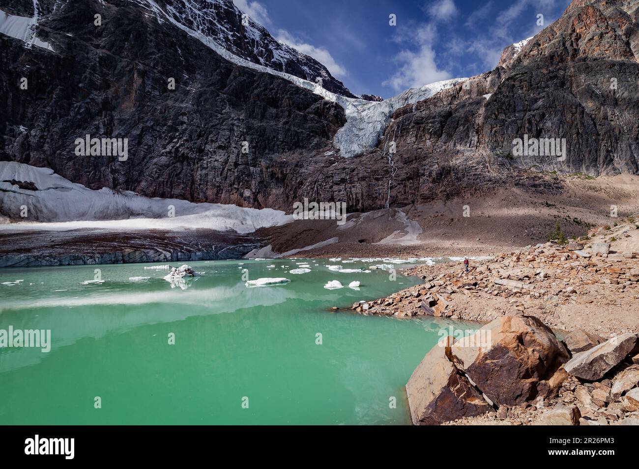 Lake at the foot of a glacier, green water, with pieces of melting ice,  turquoise color of the water, mountain cliff overlooking the lake,  dominated b Stock Photo - Alamy