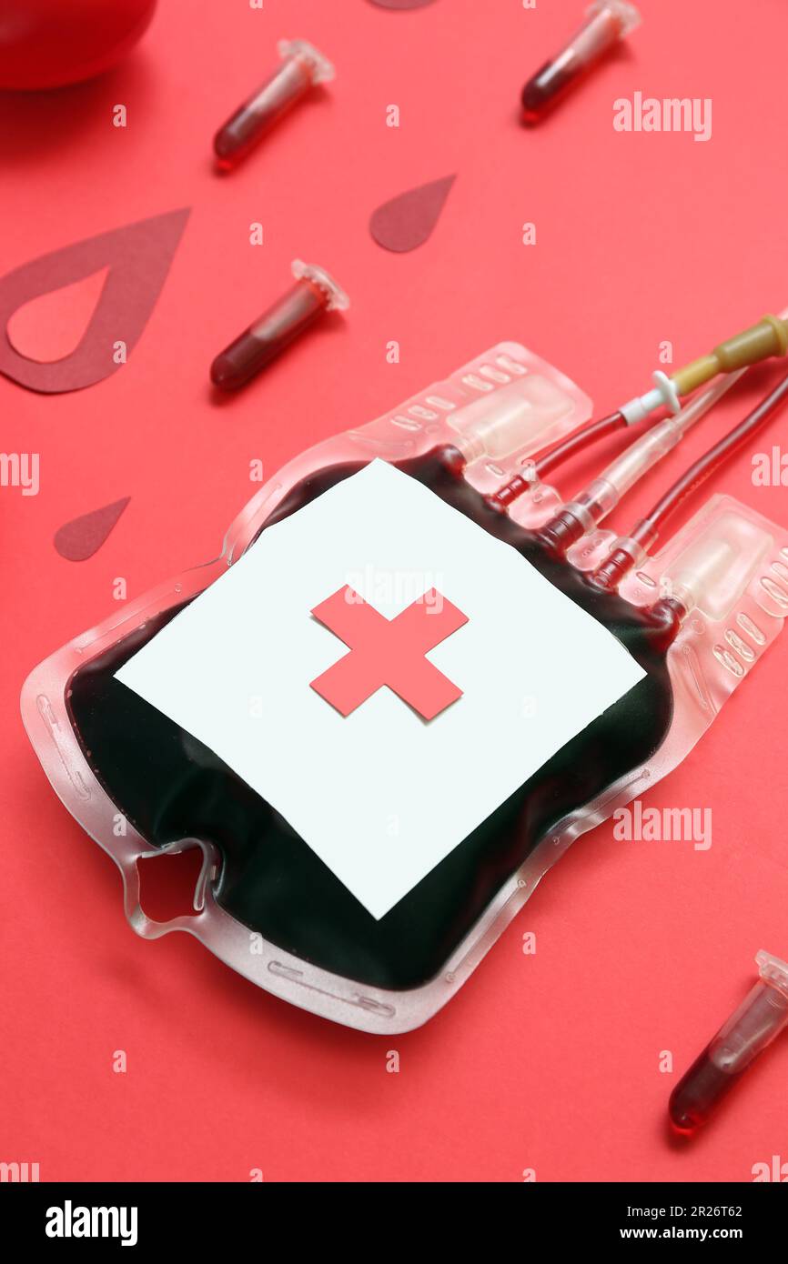 Blood pack with tubes and paper drops on red background, closeup. World ...