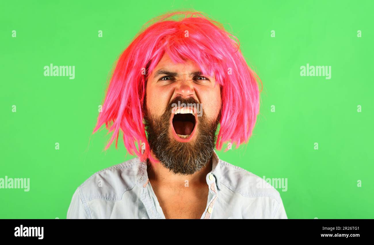 Shouting bearded man in pink wig. Angry man with beard and mustache in colored wig. Screaming guy with pink hair. Bearded male in wig. Man in periwig Stock Photo