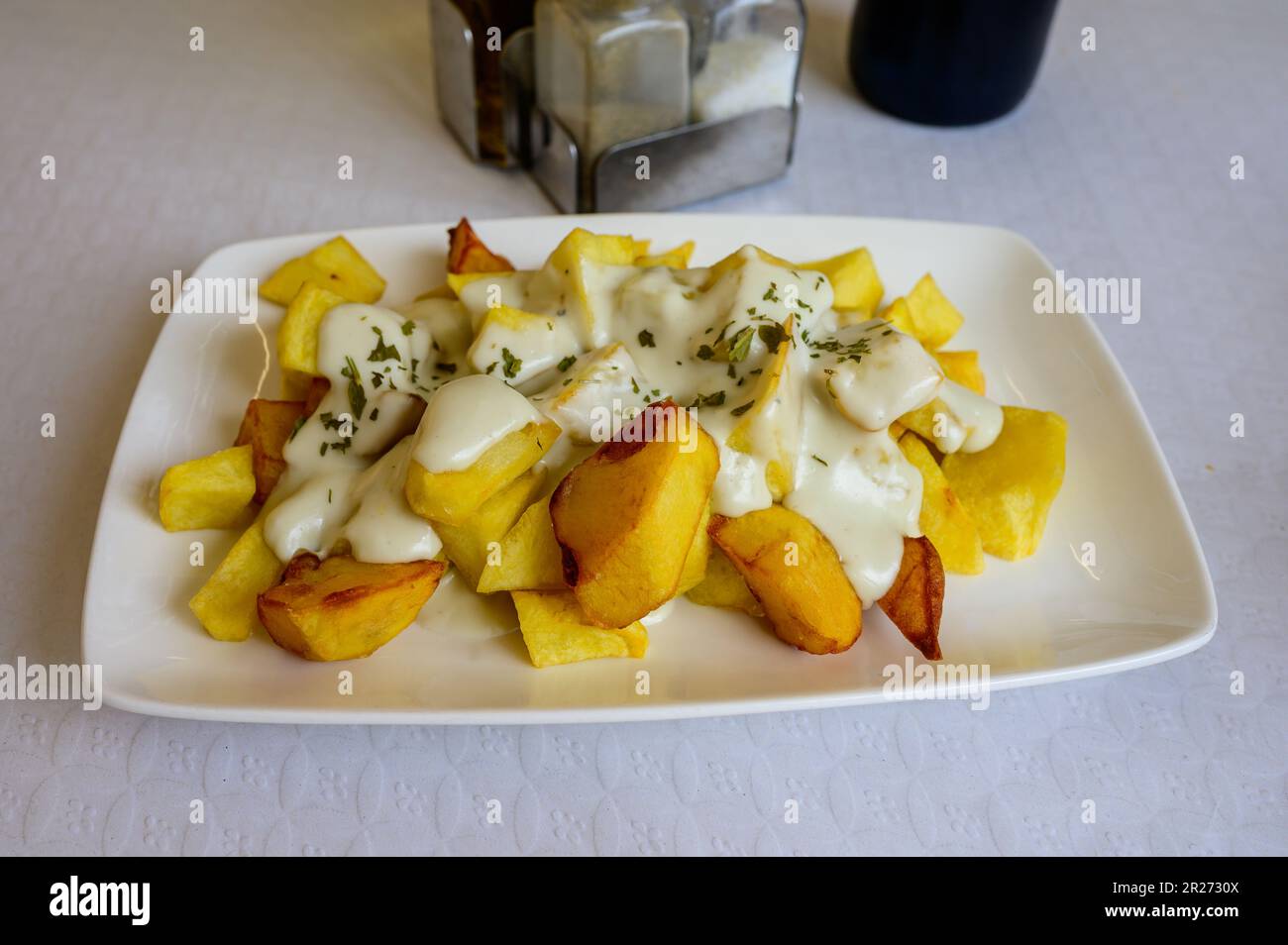 Asturian style roasted potatoes chips with melted blue cheese cabrales from Las Arenas village, Asturias, Spain Stock Photo