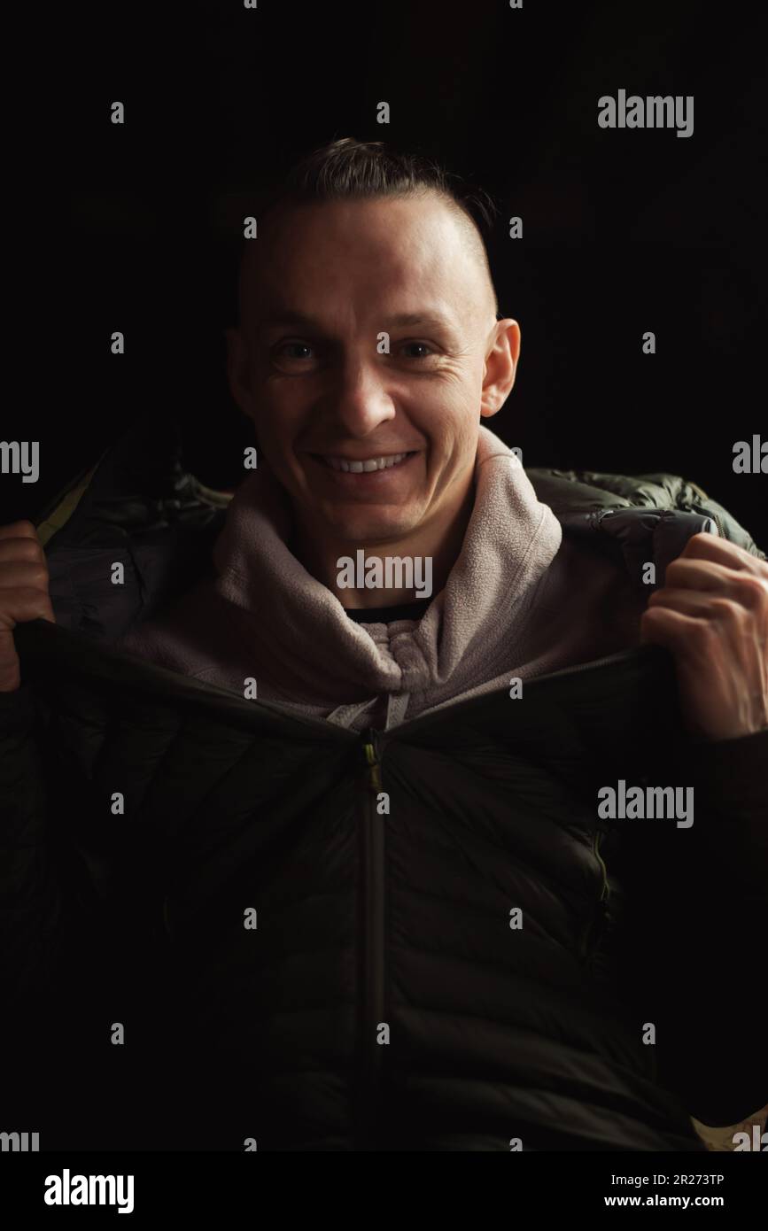 Satisfied smiling middle-aged man on a dark background. A positive person. Stock Photo