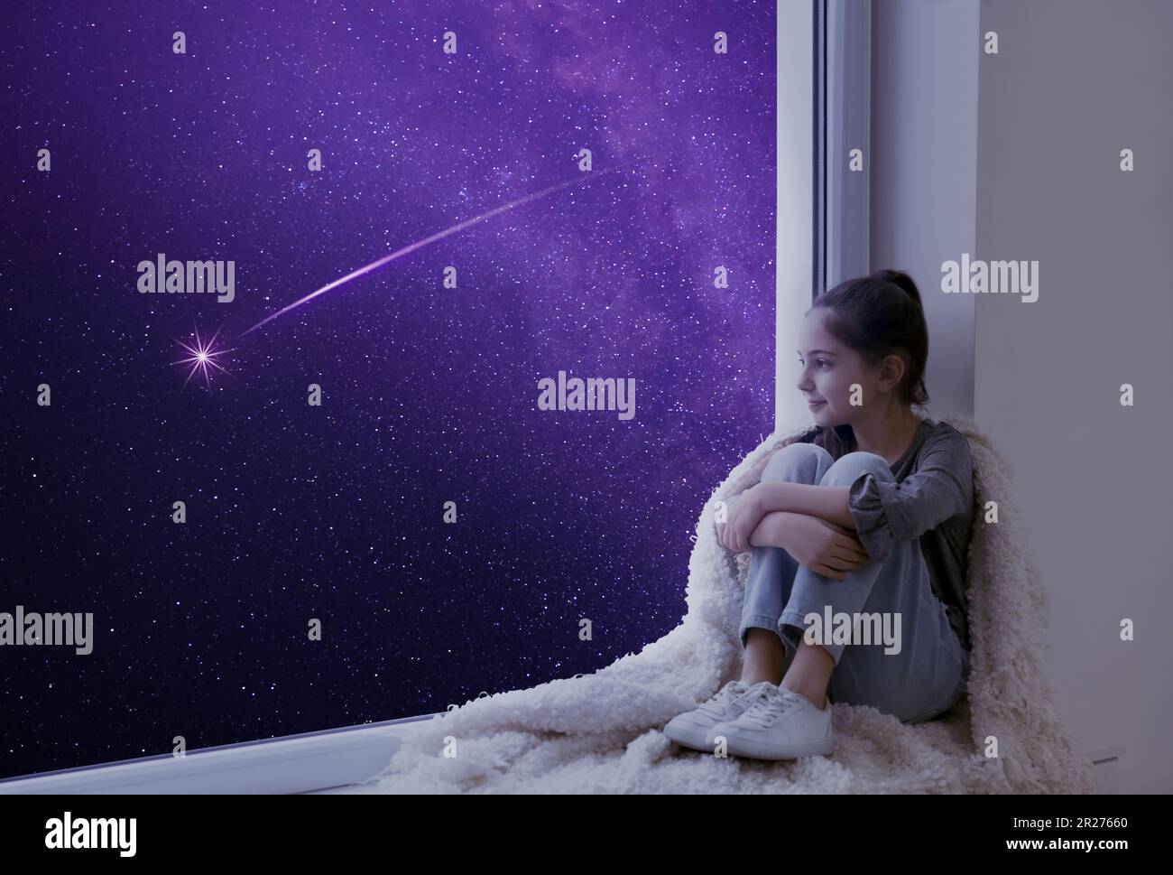 Cute little girl sitting on windowsill and looking at shooting star in ...